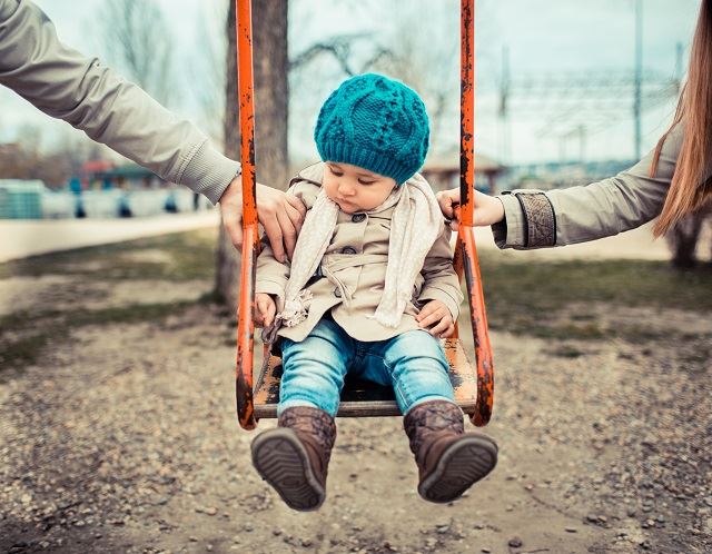 Child with parents in a swing